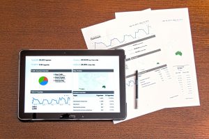 analytics on an ipad and paperwork next to it