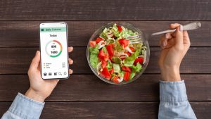 hand holding a phone with weight loss app on it 
