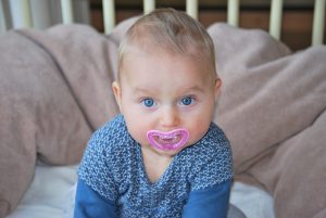 baby with a pacifier in their mouth