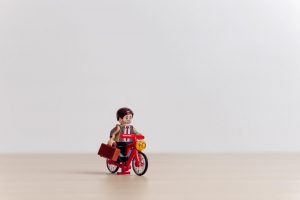 lego of a man in a suit riding a bike
