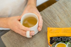 person holding a mug full of broth