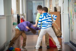 children bullying a kid in school