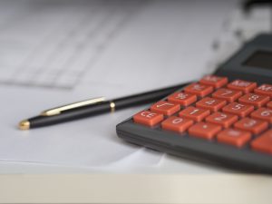calculator with a pen and paper next to it