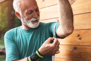 older man measuring his bicep