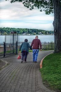 older couple holding hands walking
