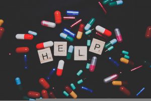 different colored pills around the word help