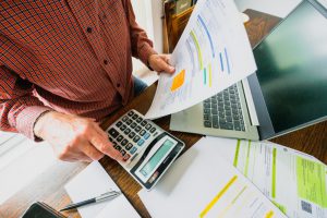 person holding bills and calculating 