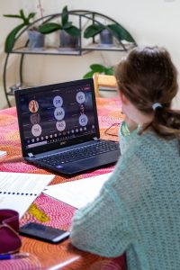 woman sitting at a table on a zoom meeting