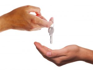 hand giving another hand a key