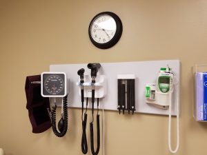 the wall of a doctor's exam room with medical equipment hung up on the wall