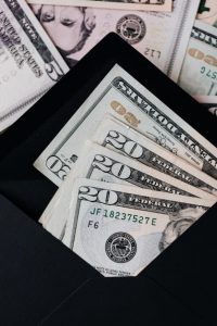 black envelope filled with money