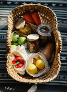 basket full of various foods like a pepper and apples