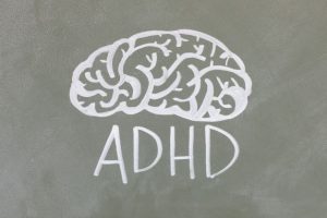 illustration of the outline of a brain written on a chalkboard with ADHD written underneath
