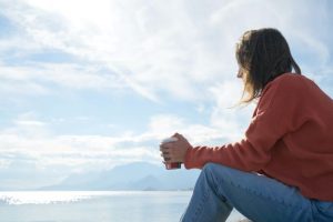 image of a woman sitting with coffee thinking