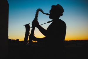 silhouette of a man playing jazz with a sunset in the background